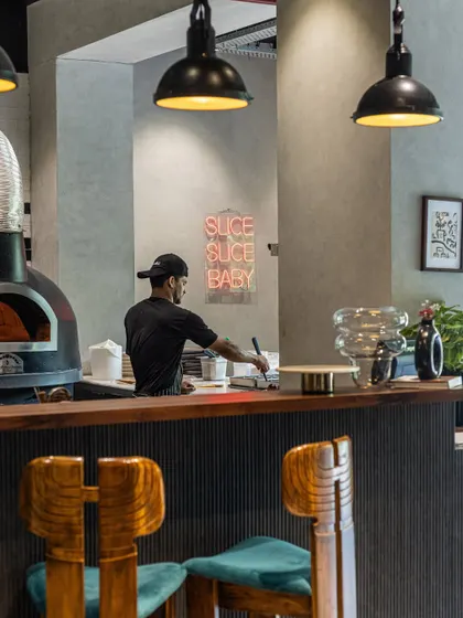 Here’s a glimpse of where the magic happens. My open kitchen, with the wood-fired oven at its heart and our pizzaiolo at work, is central to the chill, modern trattoria vibe. It’s a place to linger, watch the action, and feel like part of the family.