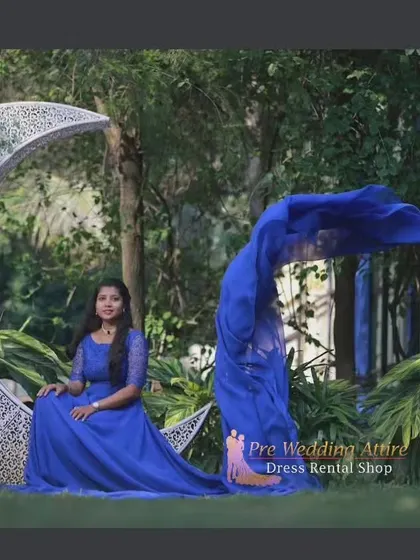 A whimsical shot with our royal blue trail gown. The model is seated on a large moon prop, with the fabric flowing around her.