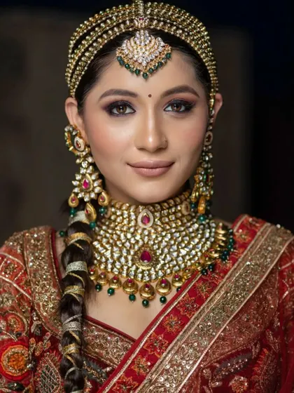 A beautiful close-up of the model's face, showing the flawless makeup and intricate hair accessory.
