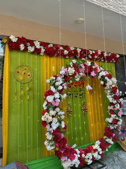 A side view of the circular floral arch, showing the depth of the flower arrangement and the festive colors of the drapes.