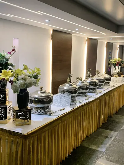 A long-table buffet setup for 50 guests in DLF Phase 1, featuring our signature silver chafing dishes and elegant floral vases.