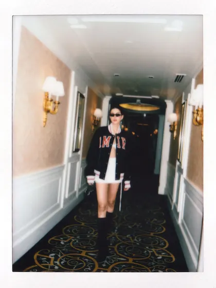A candid polaroid of Shanaya Kapoor walking down the hallway, fully in character for her modern street-style look.