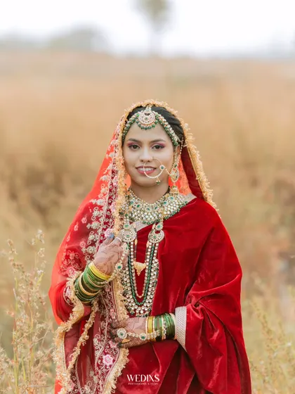 A beautiful outdoor portrait of a bride in a rich red velvet lehenga, her traditional Muslim bridal look is absolutely breathtaking.