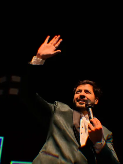 Another angle of me waving to the crowd, captured against the dark night sky. The focus is entirely on the stage and the celebration.