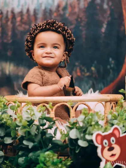 A happy little explorer in our Jungle Book themed shoot. The setup includes lush greenery, friendly animal cutouts, and a cozy basket for the perfect wild adventure portrait.