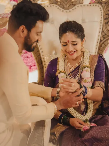 A sweet moment captured as Krishna places bangles on Milana's wrist during the ceremony.