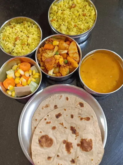 A typical lunch tiffin I prepare for my subscribers. This one includes Lemon Rice, Aloo Gobi sabzi, Dal, two Rotis, and a fresh salad to ensure a balanced and tasty meal.