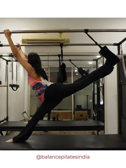 A dynamic stretch on the Cadillac machine, showing the variety of equipment we use to challenge your body.