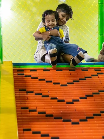 A sweet sibling hug at the top of the slide. We love being a place where families make happy memories.