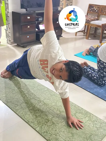 A young boy smiles as he holds a side plank, showing that building strength can be a joyful experience.