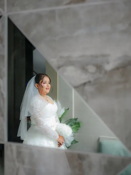 A creative portrait of a Christian bride captured through a geometric mirror, adding an artistic and modern touch to her wedding photos.