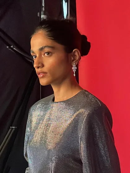 Another portrait from the same BTS series, capturing the model's profile and the elegant silver dress.