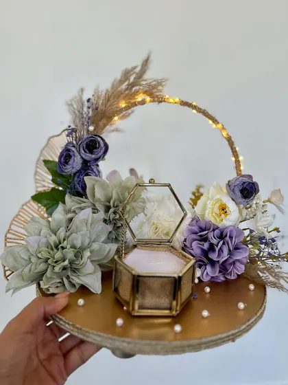 A festive ring platter, perfect for a Holi-themed or colorful engagement. The platter features a lit-up arch and a beautiful arrangement of pastel-colored flowers.