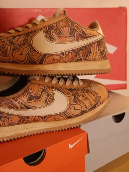 Another angle of the travel-doodled Nike Cortez, showing the intricate details covering the shoe. The coffee-dye gives it a warm, inviting look.