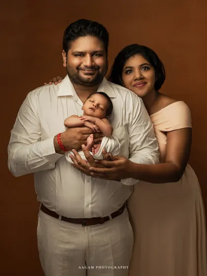 The first family portrait. This classic fine art photo shows the new parents standing proudly with their sleeping newborn, a timeless keepsake of when they became three.