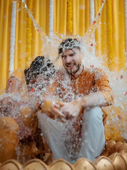 An explosion of fun at the Haldi ceremony. I used a fast shutter speed to freeze the splash of water, capturing the couple's surprise and delight in this playful ritual.