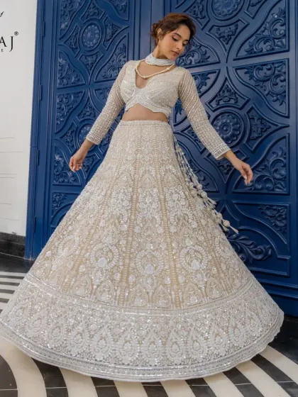This blush lehenga with its full, flowing skirt and intricate hand-embellishments is a masterpiece of contemporary artistry and timeless elegance.