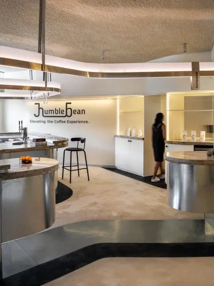The color and texture palette was inspired by coffee itself. The sprayed acoustic ceiling mimics the froth of a cappuccino, while the floors and walls reflect the tones of a latte.