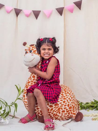 A sweet smile and a comfy dress. This red and navy check frock is perfect for pairing with a favorite stuffed animal for a day of imaginative play.