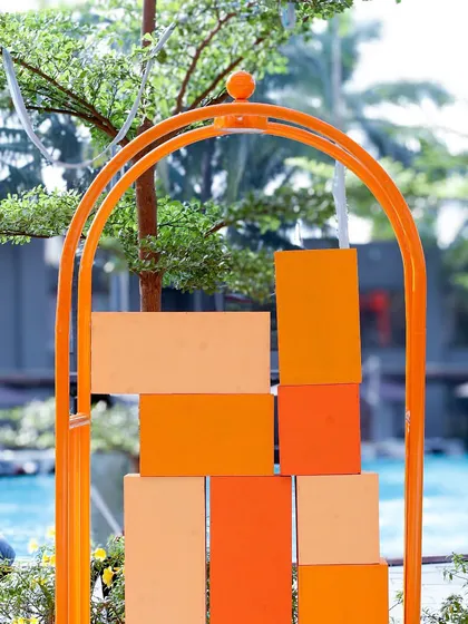 A modern, abstract decor piece in shades of orange, placed by the pool to enhance the Mexican-themed ambiance.