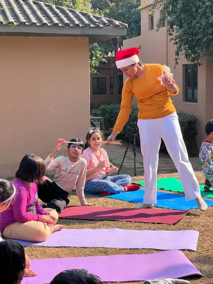Celebrating Christmas with our little yogis. A teacher shares treats with the children during a special holiday themed yoga session in the park.