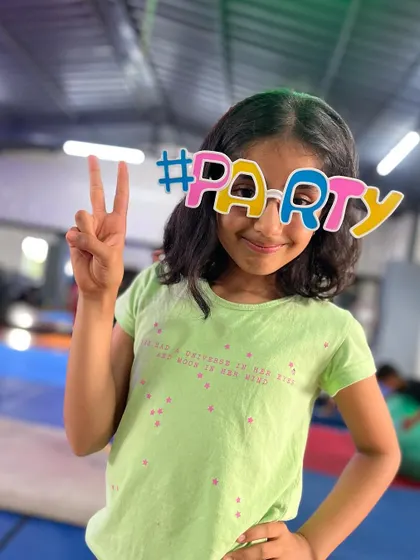 Peace and party vibes. This student is all smiles, showing off her fun glasses and positive attitude.