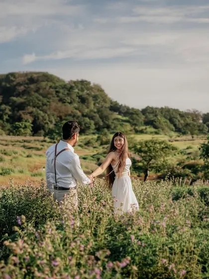 Holding hands and walking through a field of flowers. This is a simple yet powerful image of their journey together.