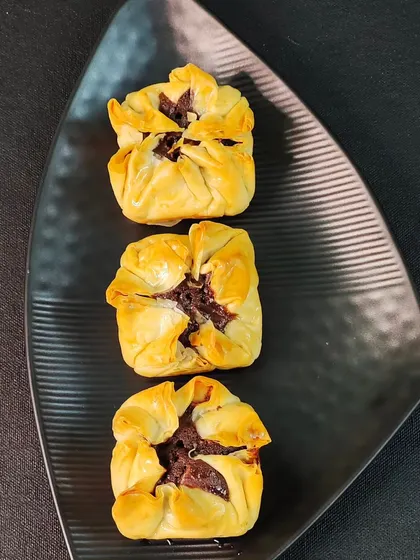 My innovative Baklava Brownie Bites. These unique treats feature a rich brownie filling wrapped in flaky, golden-brown phyllo pastry, offering a delightful fusion of two classic desserts.