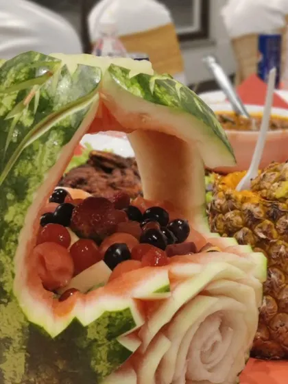 Another one of our artistic fruit carvings. This watermelon is carved into a basket with a delicate rose pattern, filled with fresh berries and melon balls.
