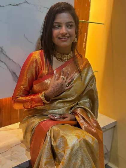 A close-up of Sonu, her hand on her heart, looking content and beautiful.