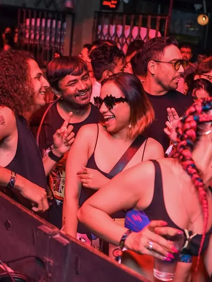 Friends laughing and dancing by the DJ booth. The best spot in the house.
