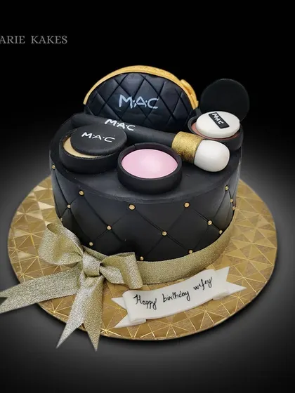 For the makeup enthusiast, this cake is designed to look like a MAC makeup bag. It features a quilted black fondant finish and is topped with edible versions of MAC products like powder, blush, and brushes.