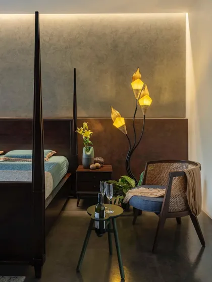 A detail shot of a bedroom corner, where a sculptural floor lamp and curated decor create a sophisticated and personal ambiance.