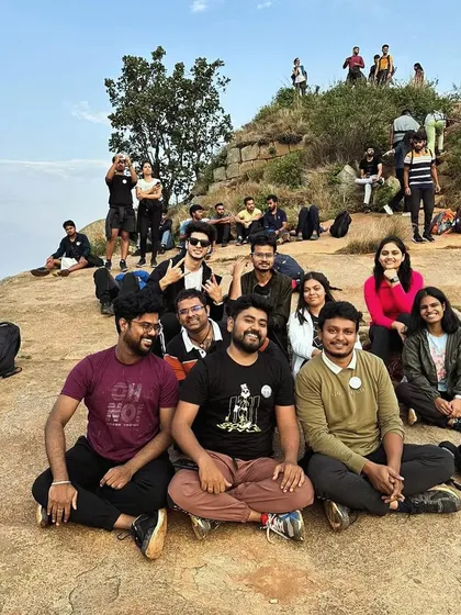 Resting and enjoying the morning view at Skandgiri. Our treks include planned breaks for rest, hydration, and soaking in the natural beauty.
