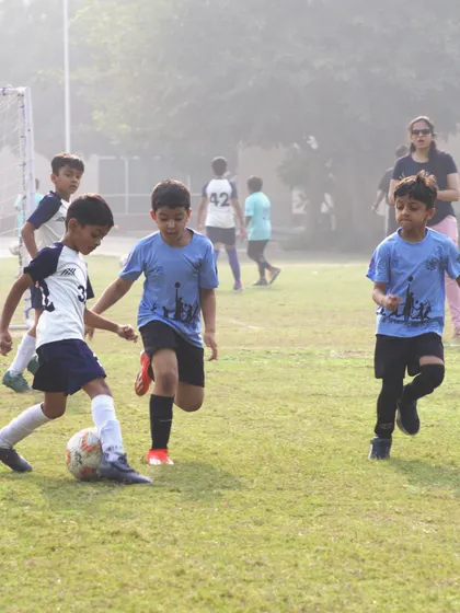 Two young opponents battle for possession in a School Soccer League match. These moments of healthy competition are where skills are tested and sportsmanship is learned on the field.