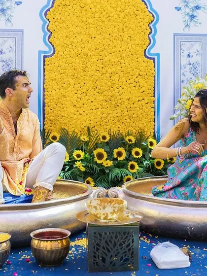A wide shot showing the beautiful, vibrant decor and the fun setup for this Delhi Haldi ceremony.