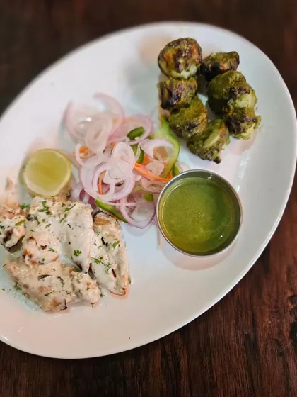 A closer look at our Malai Soya Chaap and Hariyali Mushroom Tikka, served with sliced onions and a wedge of lime. These starters are perfect for any vegetarian catering menu.