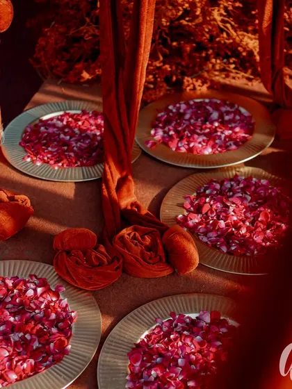 Plates filled with fresh rose petals await guests for the celebration. It's a small touch that adds a layer of tradition, fragrance, and beauty to the event.