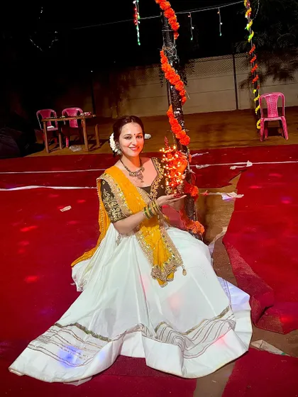 A quiet moment amidst the Garba night celebrations. I am holding a traditional lamp, dressed in a beautiful chaniya choli for the event.