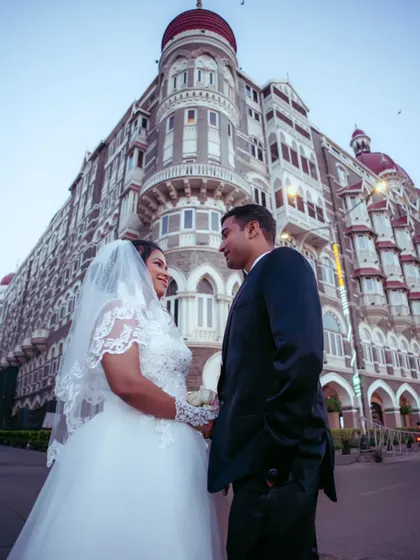 An impressive shot of a couple posing in front of the Taj Mahal Palace Hotel, a grand and iconic pre-wedding photo.
