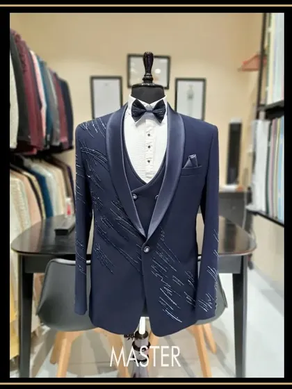 For the groom who wants to make a statement. This navy blue three-piece tuxedo features a unique shawl lapel and delicate crystal work, designed to make your special day even more memorable.
