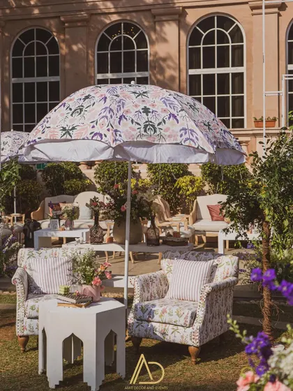 A lovely outdoor seating area under a custom-printed umbrella, creating a perfect spot for guests to relax and enjoy the garden party atmosphere.