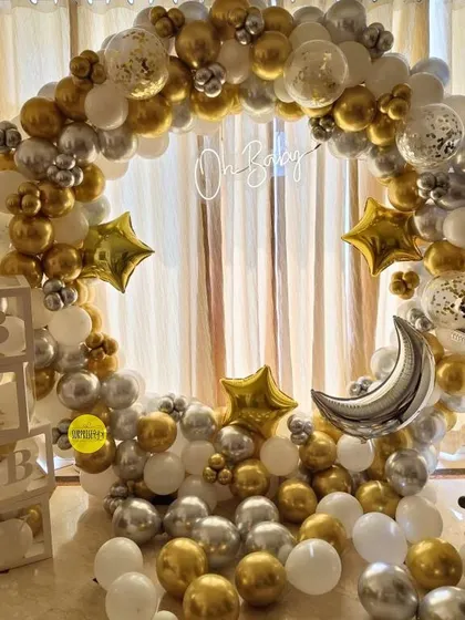 A "Twinkle Twinkle Little Star" themed baby shower. This full circular balloon arch in gold, silver, and white, complete with star and moon foil balloons, creates a magical and dreamy atmosphere.
