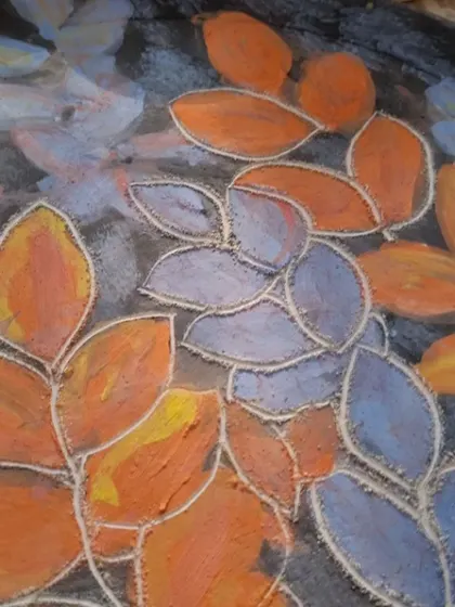 A close up of the texture created by sgraffito. You can see how the carved lines add depth and detail to the painted leaves.