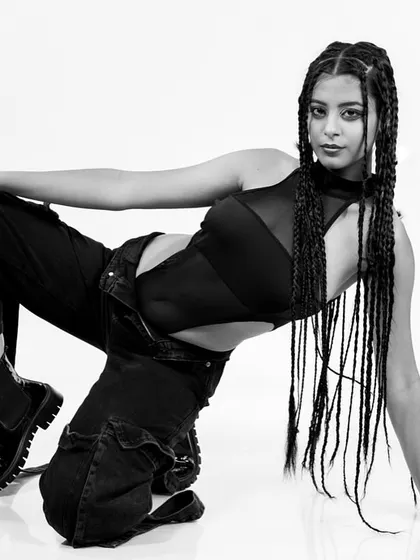 A dynamic, high-contrast black and white shot of a model in a low pose, her long braids creating a graphic element. This is a prime example of my work for high-fashion editorials.