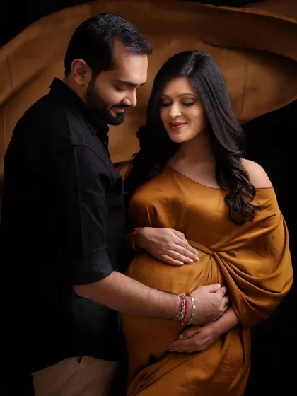 Earthy, elegant, and timeless. This luxe brown gown against a dark backdrop offers a sophisticated and high-fashion alternative for a maternity shoot.