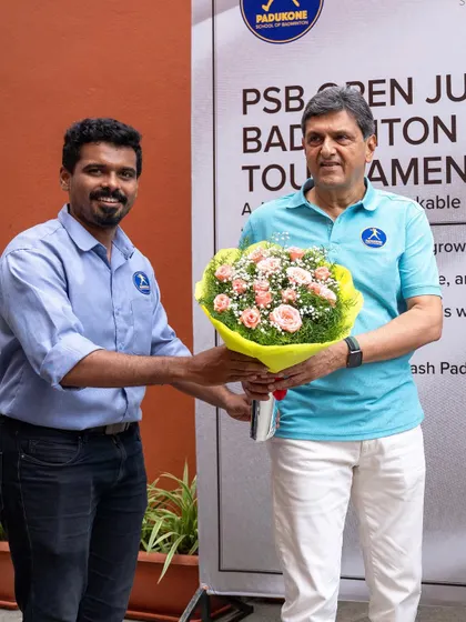 A coach presents a bouquet to Prakash Padukone at a junior tournament. We celebrate our founder's legacy by fostering the next generation of badminton talent.