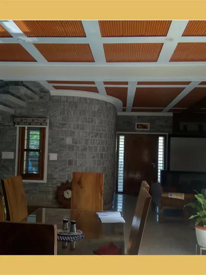 A dining area with a coffered ceiling featuring terracotta filler tiles, set against a curved stone wall.
