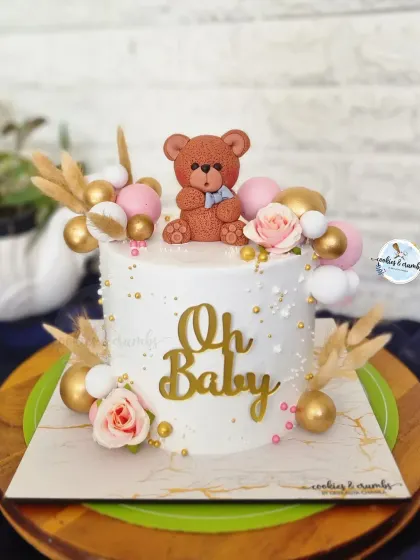 Another sweet "Oh Baby" cake for a baby shower. This one combines a cute teddy bear with soft pink roses, gold spheres, and dried botanicals for a chic and modern look.