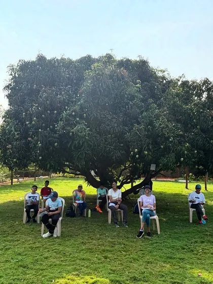 Campers sit for a reflection and assessment session under a large tree. We conclude our camps by helping participants reflect on their growth and the skills they've learned.